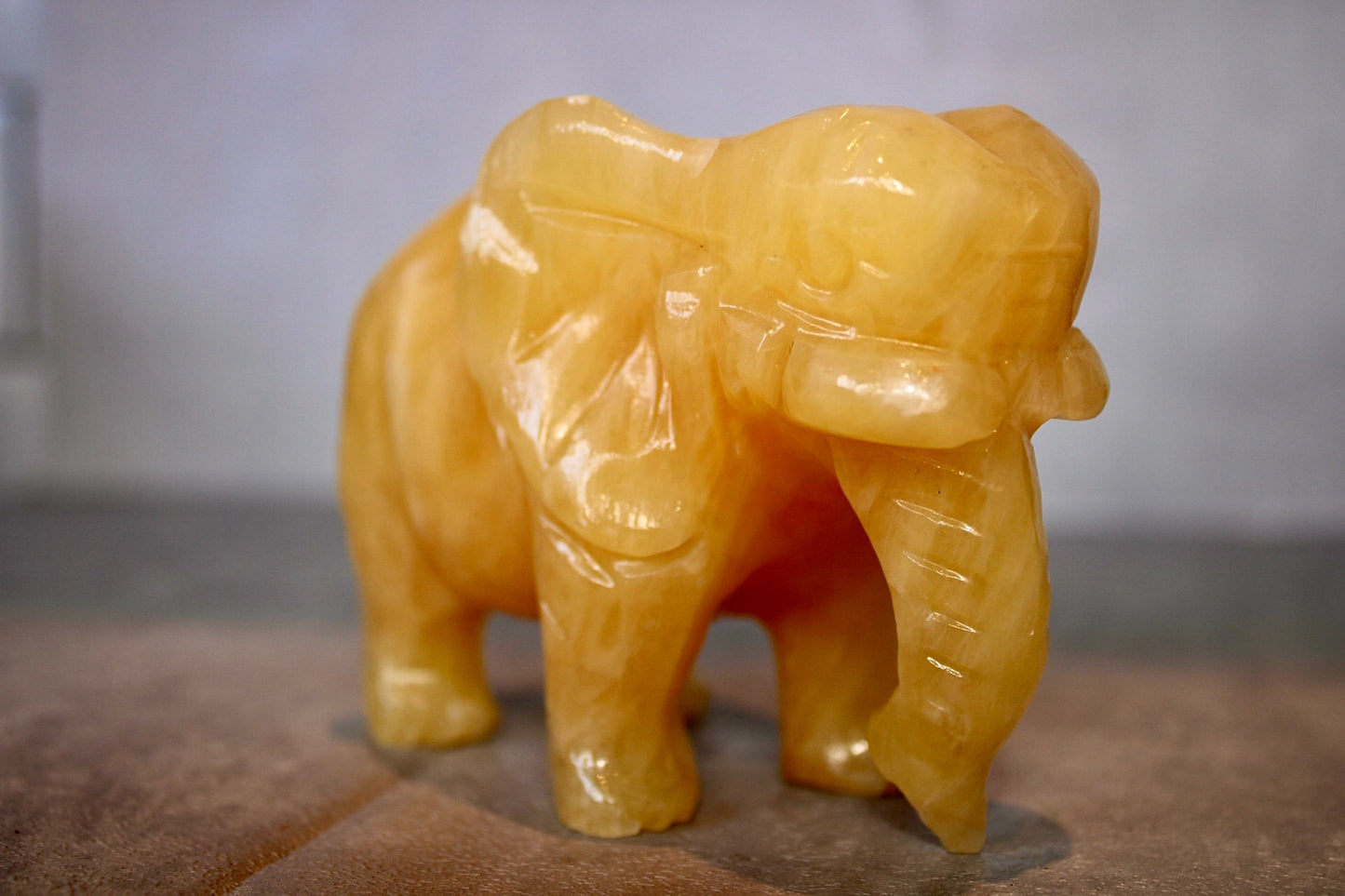 Large, orange calcite elephant carving 8cm(H) 10cm(L)