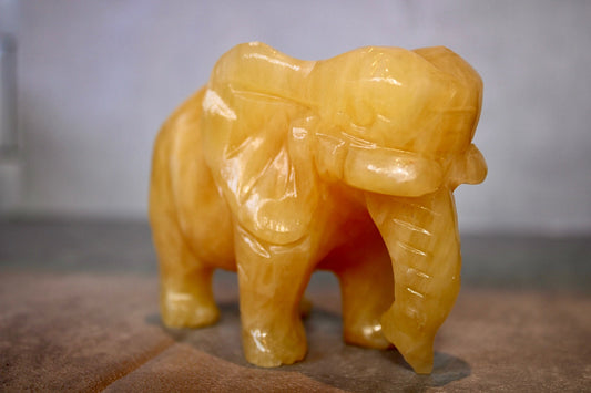 Large, orange calcite elephant carving 8cm(H) 10cm(L)