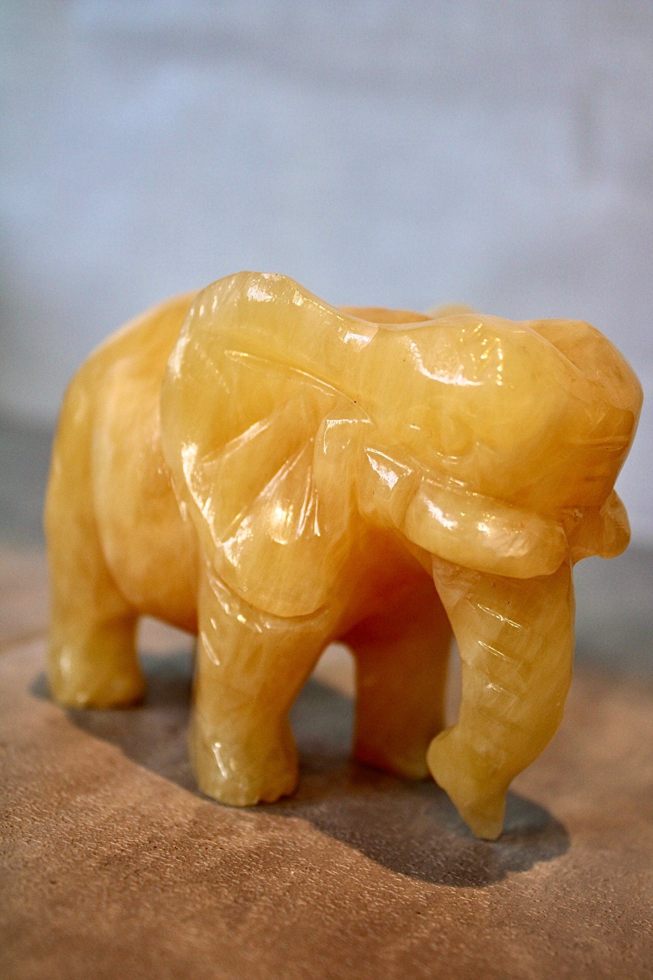 Large, orange calcite elephant carving 8cm(H) 10cm(L)