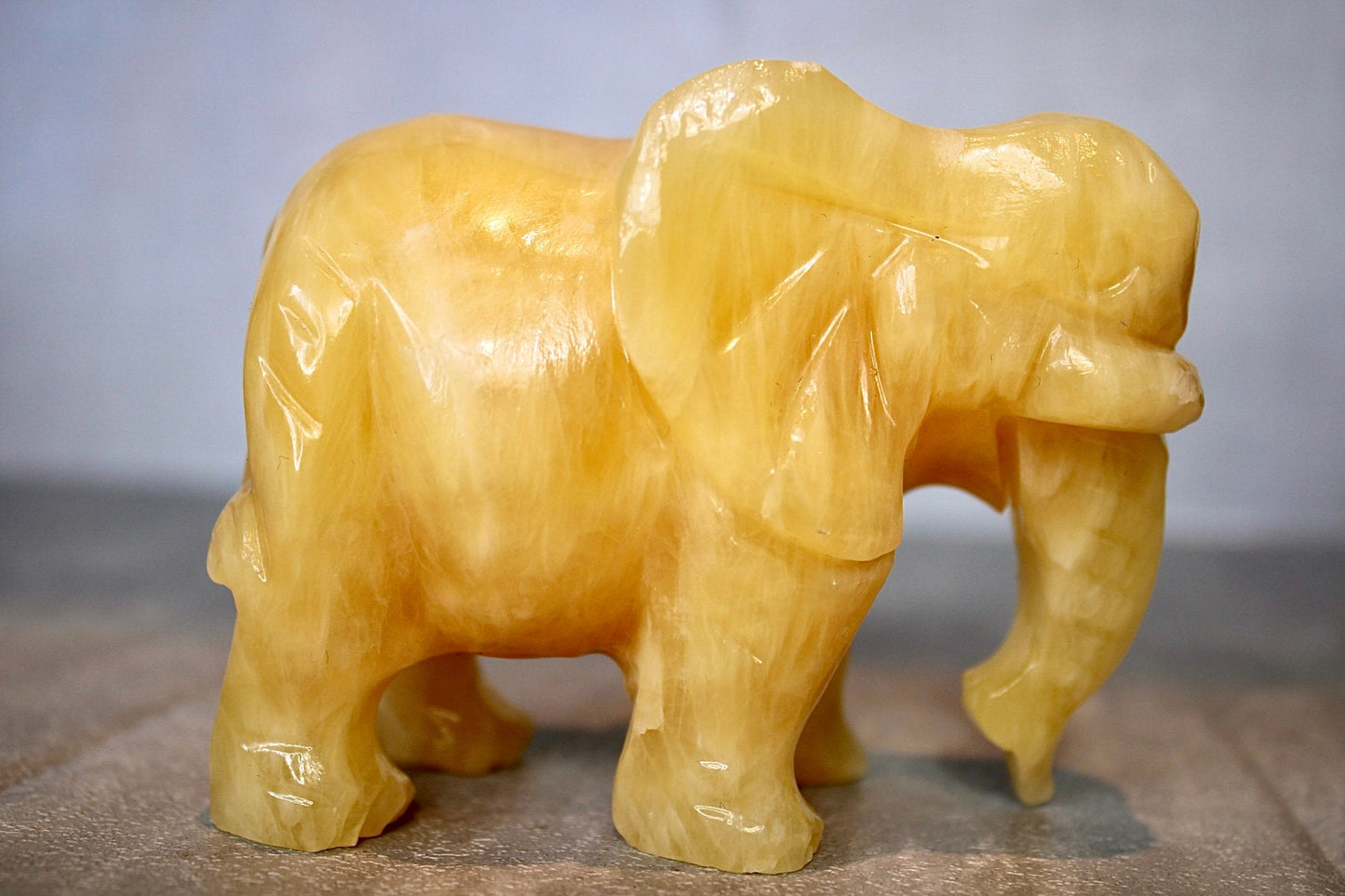 Large, orange calcite elephant carving 8cm(H) 10cm(L)