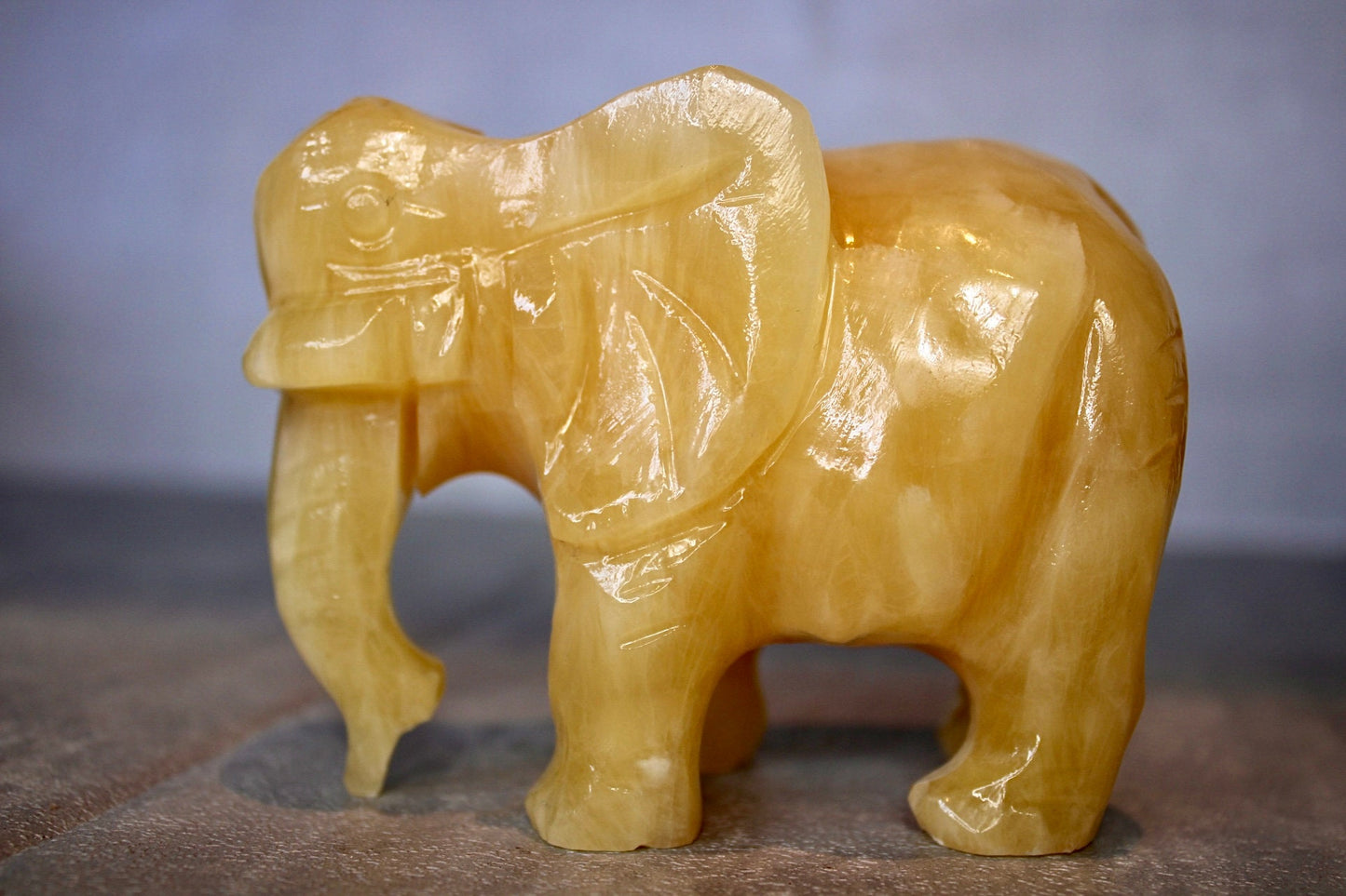 Large, orange calcite elephant carving 8cm(H) 10cm(L)