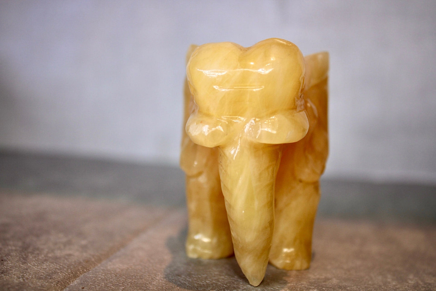 Large, orange calcite elephant carving 8cm(H) 10cm(L)